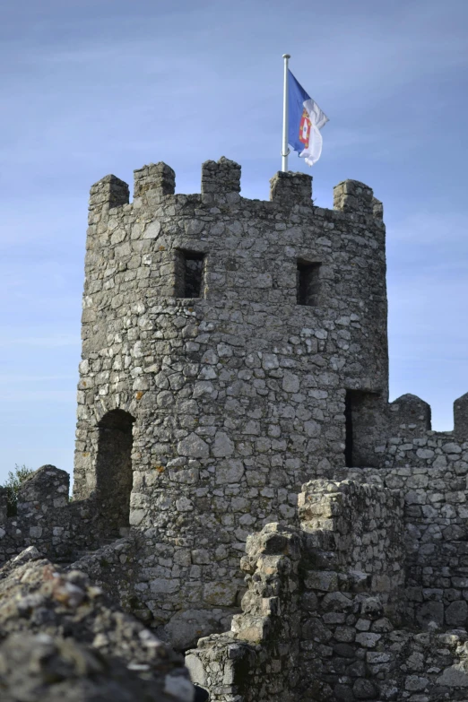 a castle with a flag on top of it, granite, portugal, looking menacing, high walls