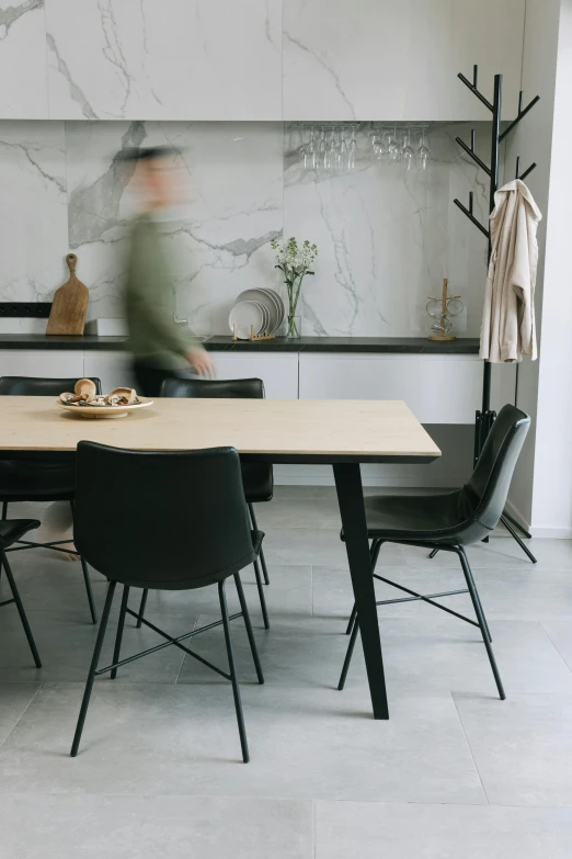 a blurry picture of a person sitting at a table, by Jan Tengnagel, unsplash contest winner, on kitchen table, leather and suede, walking to the right, modern minimalist f 2 0 clean