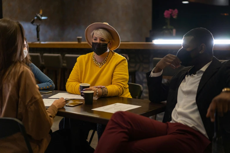 a group of people sitting around a wooden table, masks, dark people discussing, uncropped, professional image