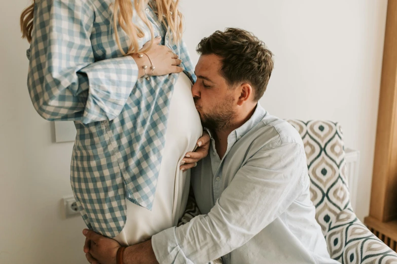 a woman standing next to a man holding a pillow, by Will Ellis, pexels contest winner, happening, pregnant belly, close up shot from the side, avatar image, lachlan bailey