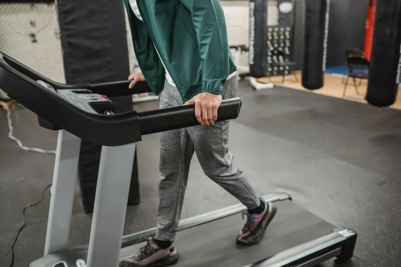 a man walking on a treadie in a gym, profile image, still photograph, clinical, mechanical