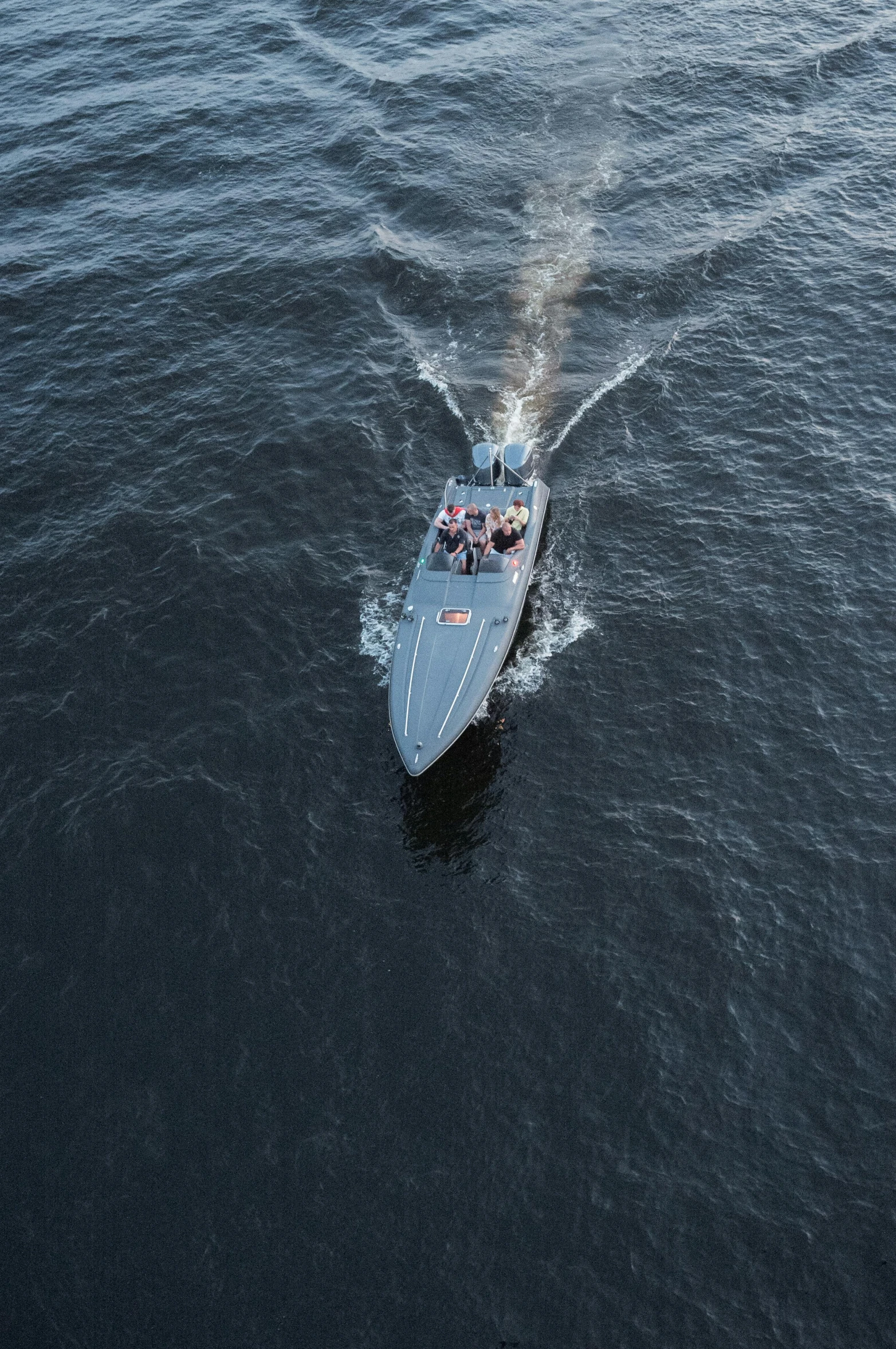 a small boat traveling across a large body of water, by Jens Jørgen Thorsen, pexels contest winner, hurufiyya, top view of convertible, gunfire, grey, thumbnail