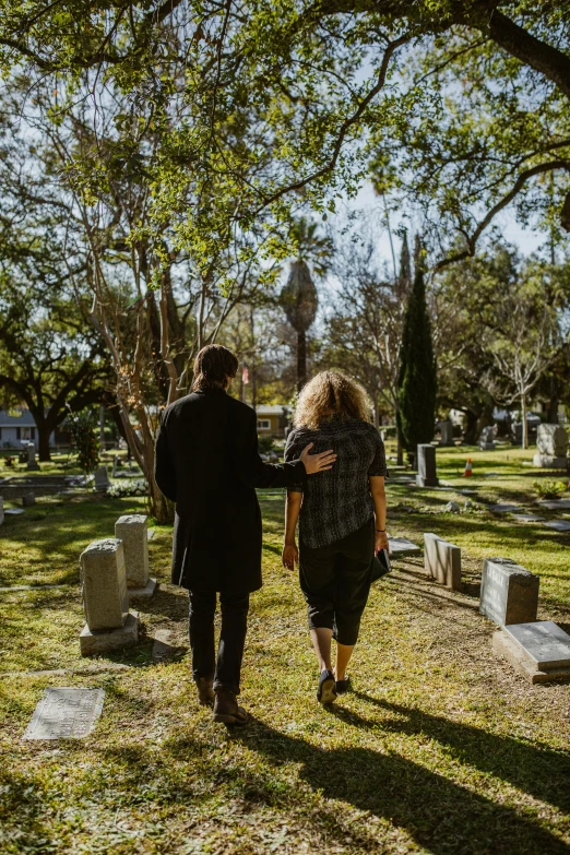 a man and woman walking through a cemetery, by Meredith Dillman, pexels, jen atkin, los angelos, back towards camera, cast