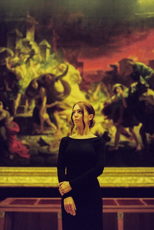 a woman standing in front of a painting, inspired by Théodore Chassériau, pexels contest winner, renaissance, emma watson as she-hulk, wearing a black dress, karen gillan, in a large cathedral