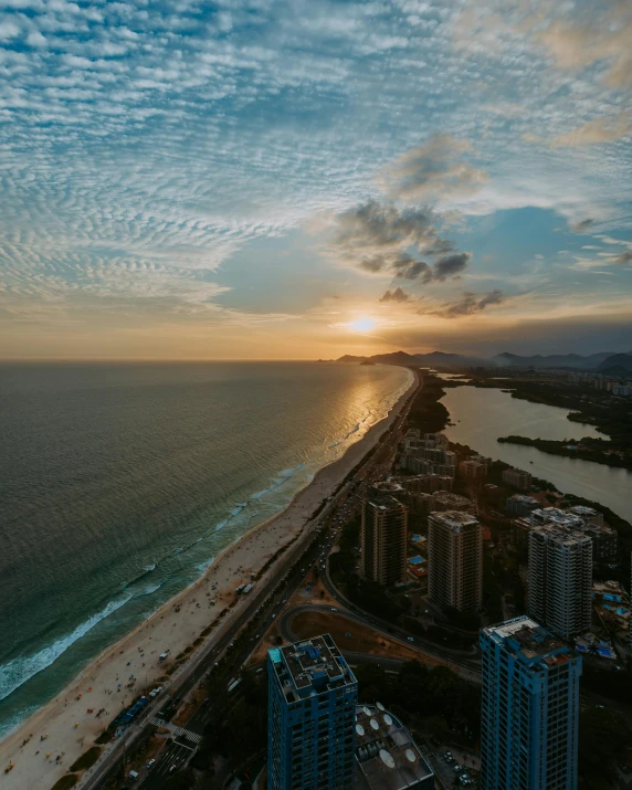 a large body of water next to a beach, by Seb McKinnon, pexels contest winner, oscar niemeyer, bird's eye view of a city, sunset photo, today\'s featured photograph 4k