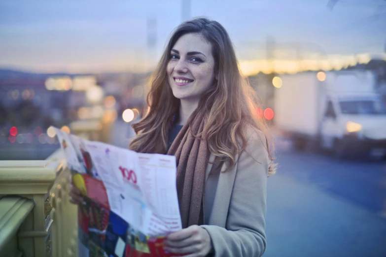 a woman standing on a bridge holding a map, pexels contest winner, happening, newspaper picture, handsome girl, in the evening, headshot
