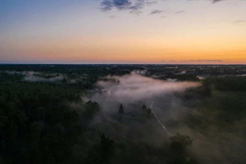 an aerial view of a foggy forest at sunset, pexels contest winner, wide angle shot 4 k hdr, misty ghost town, drone photograpghy, misty swamp