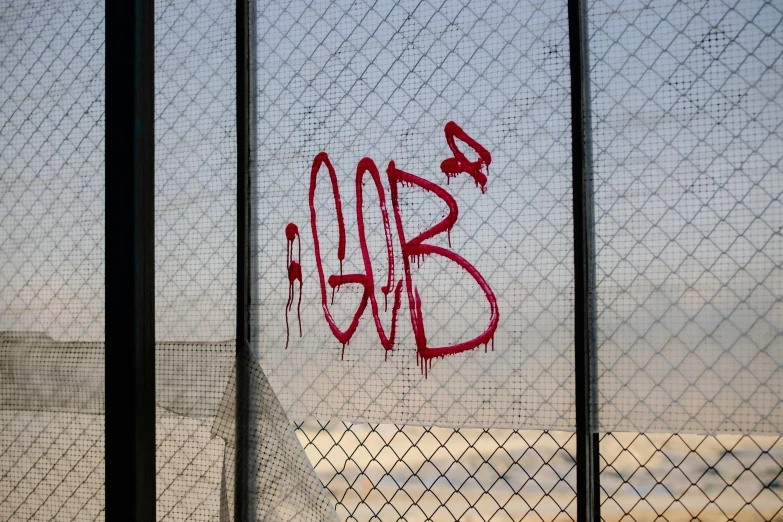 a close up of a fence with graffiti on it, f 4. 0, the blob, glenn barr, red mesh in the facede