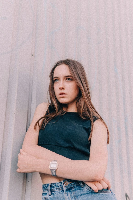 a woman leaning against a wall with her arms crossed, an album cover, by Winona Nelson, trending on unsplash, portrait sophie mudd, she is wearing a black tank top, sydney sweeney, “ iron bark