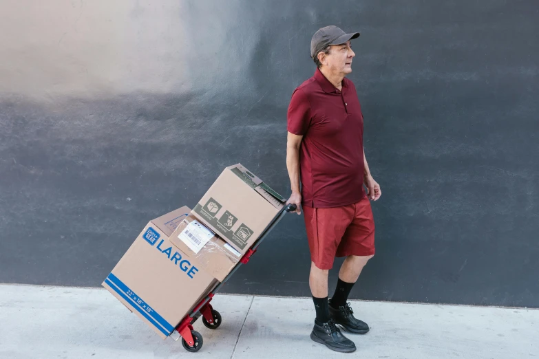 a man pushing a cart with boxes on it, a portrait, by Daniel Schultz, wearing red shorts, full body full height, avatar image, professional portrait photo
