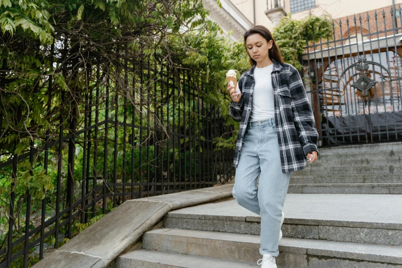 a woman walking up some steps eating an ice cream, trending on pexels, flannel, androgynous person, high quality product image”, walking at the garden