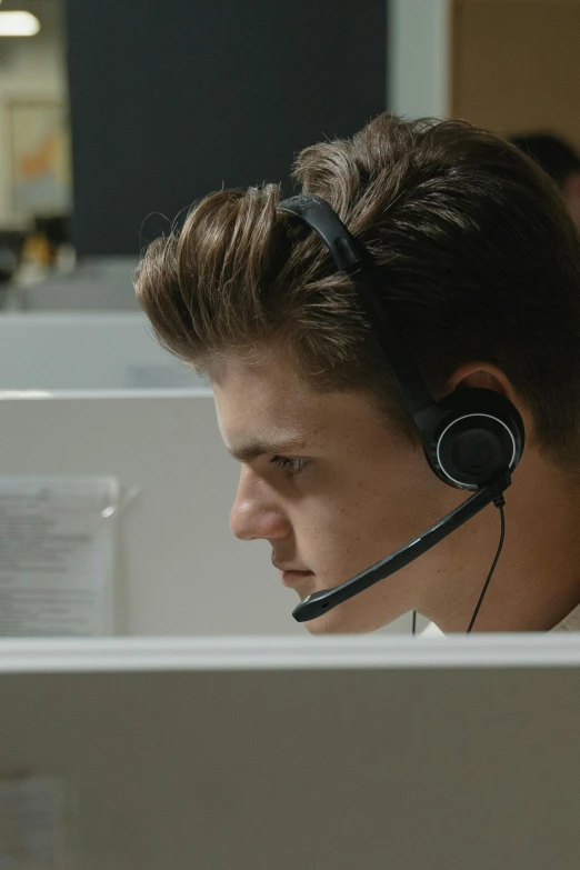 a man wearing a headset sitting in front of a computer, inspired by John Luke, unbroken, ignant, worksafe. cinematic, coworkers