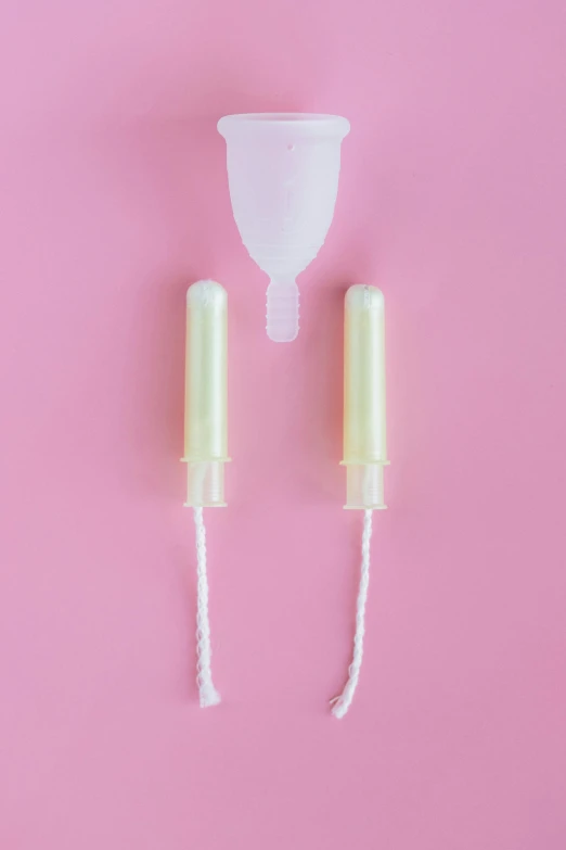 a couple of toothbrushes sitting on top of a pink surface, by Ellen Gallagher, plasticien, surgical iv drip, cervix awakening, hanging, vanilla