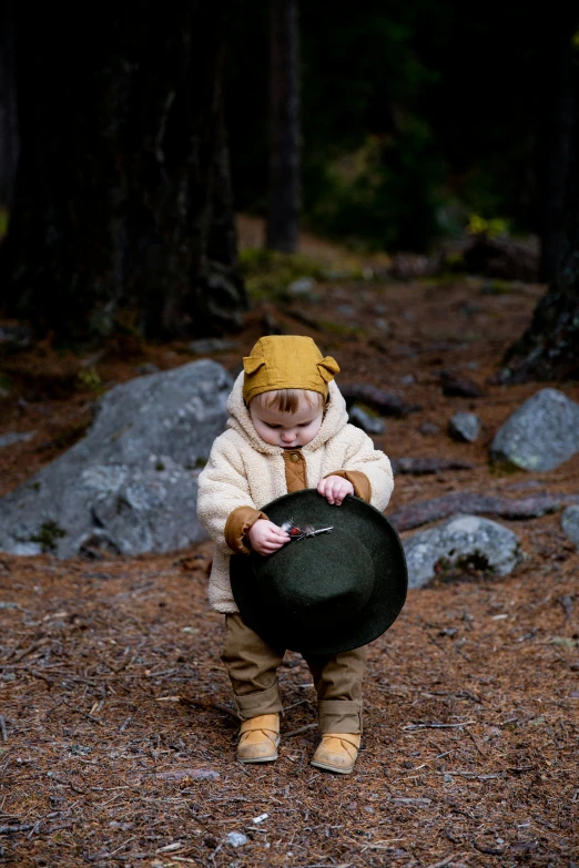 a small child holding a hat in a forest, unsplash, purism, bear with scales, high quality photo, full costume, poop