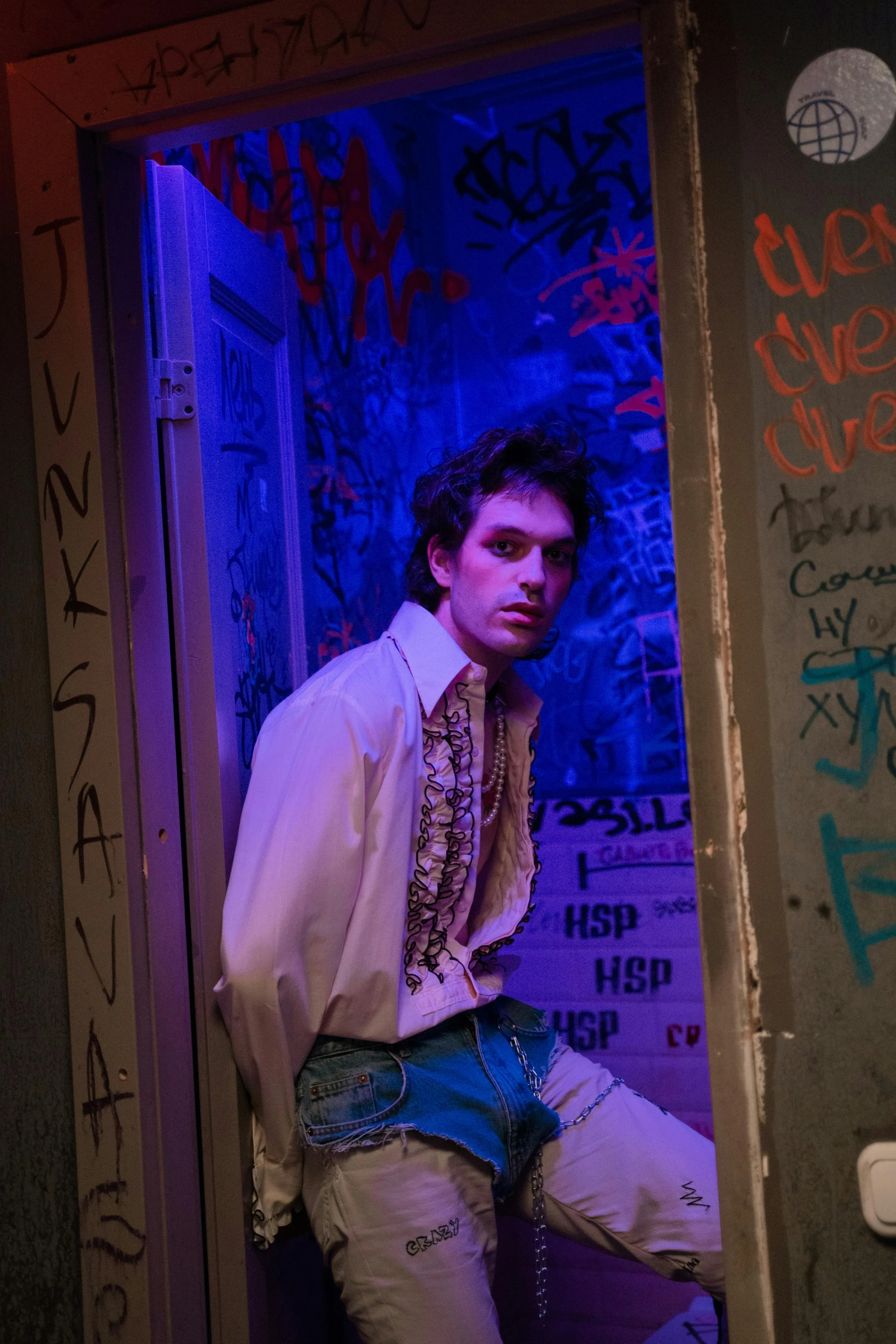 a man standing in a doorway with graffiti on the walls, inspired by Nan Goldin, renaissance, timothee chalamet, production photo, [ theatrical ], recital