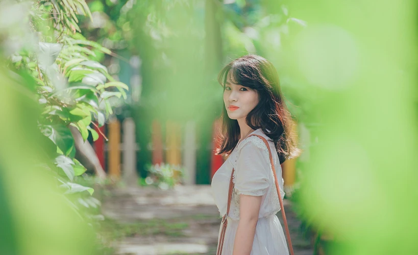 a woman in a white dress holding a brown bag, by Tan Ting-pho, pexels contest winner, light green tone beautiful face, ancient garden behind her, korean girl, 256435456k film