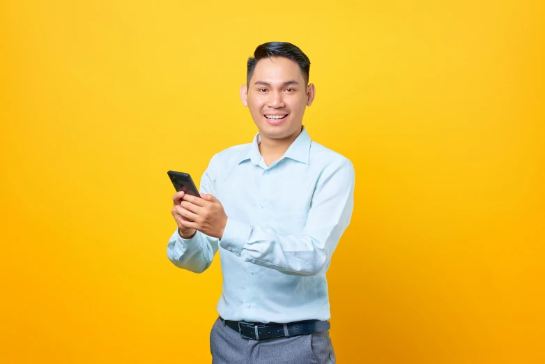 a man standing in front of a yellow wall holding a cell phone, avatar image, asian male, commercial photo, profile picture 1024px