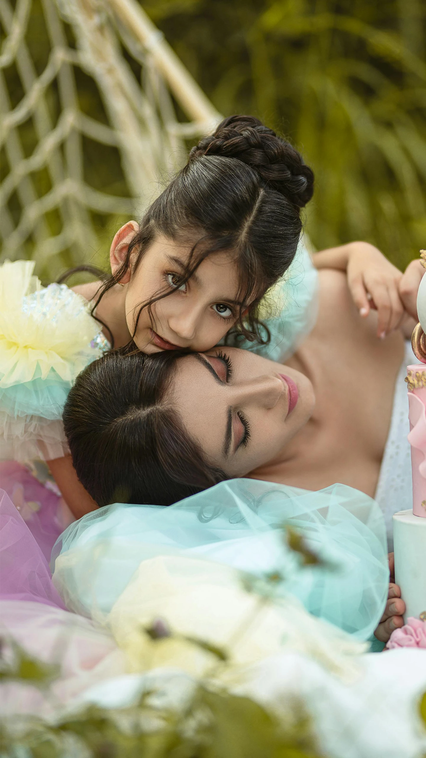 a woman and a little girl laying in a hammock, a colorized photo, by Maryam Hashemi, trending on pexels, fairy look, pastel', dua lipa, chiffon