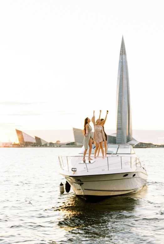 a group of people standing on top of a boat, pexels contest winner, modernism, 3 young and beautiful women, waving, on a super yacht, architectural masterpiece