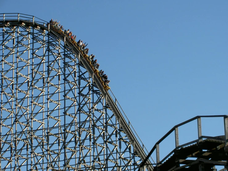 a group of people standing on top of a roller coaster, wooden platforms, black lightning, up close image, from afar