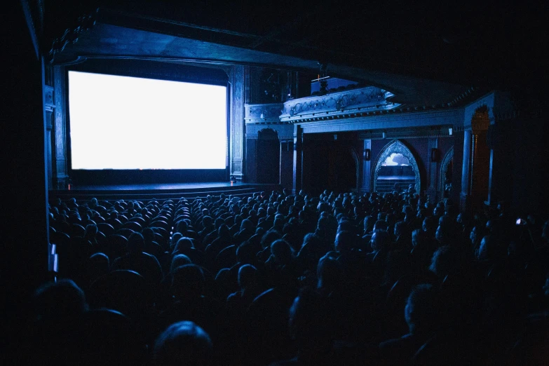 a large auditorium full of people watching a movie, by Adam Rex, pexels, video art, pitch black room, an old cinema, instagram post, cinestill 800t eastmancolor