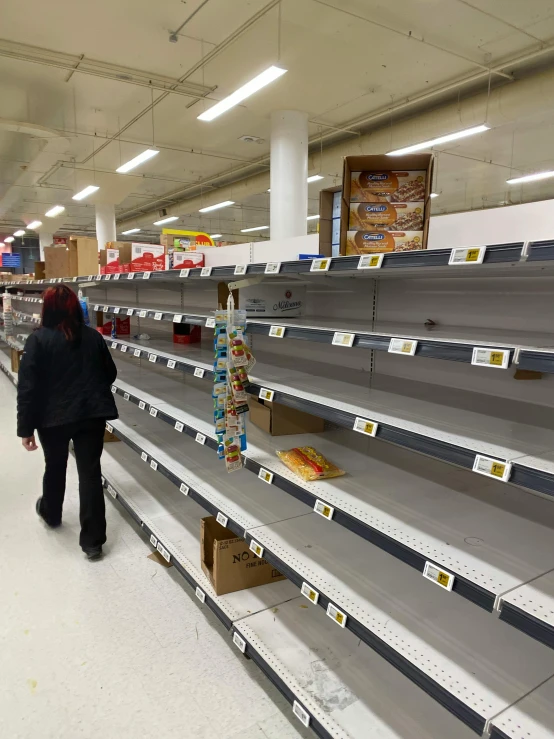 a woman walks past empty shelves in a grocery store, a photo, reddit, 2 5 6 x 2 5 6 pixels, devastated, enso, people watching around