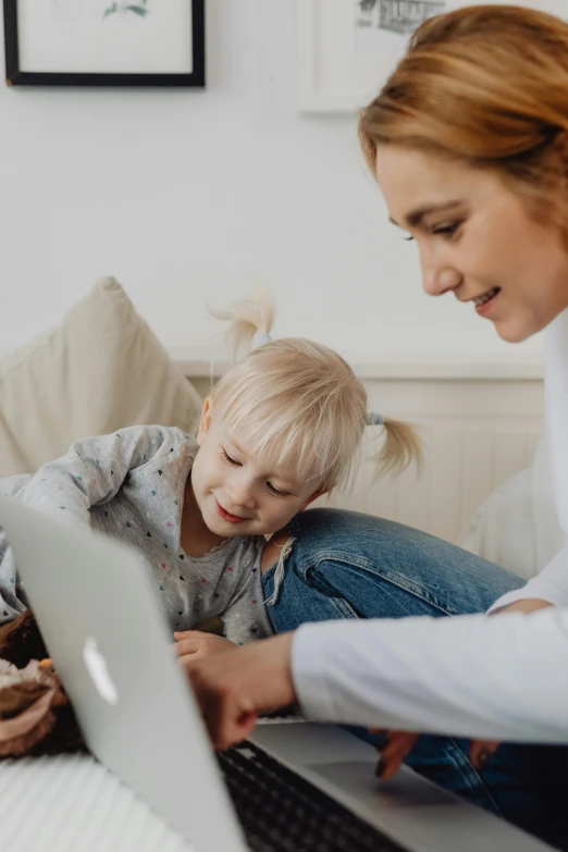 a woman and child sitting on a couch looking at a laptop, pexels contest winner, a blond, medium shot of two characters, healthcare, programming