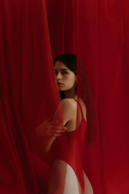 a woman standing in front of a red curtain, inspired by Elsa Bleda, pexels contest winner, renaissance, kaya scodelario, red flags, album cover, anatomy