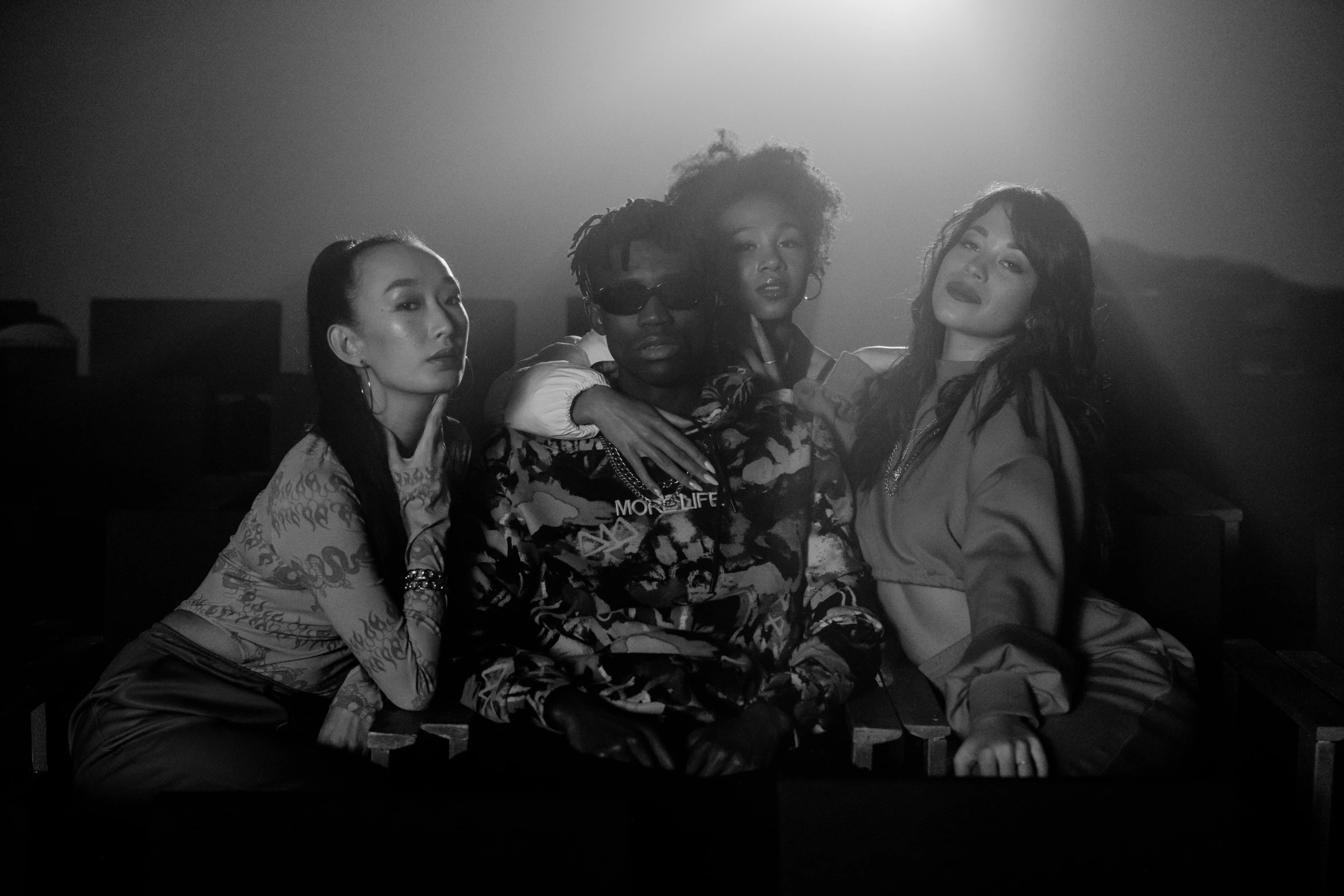 a group of women sitting next to each other, a black and white photo, young thug, taejune kim, black main color, lit from above