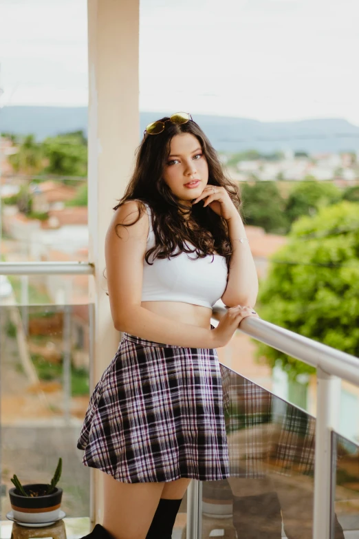 a woman standing on a balcony next to a potted plant, a picture, by Felipe Seade, instagram, wearing crop top and miniskirt, avatar image, teenager, headshot