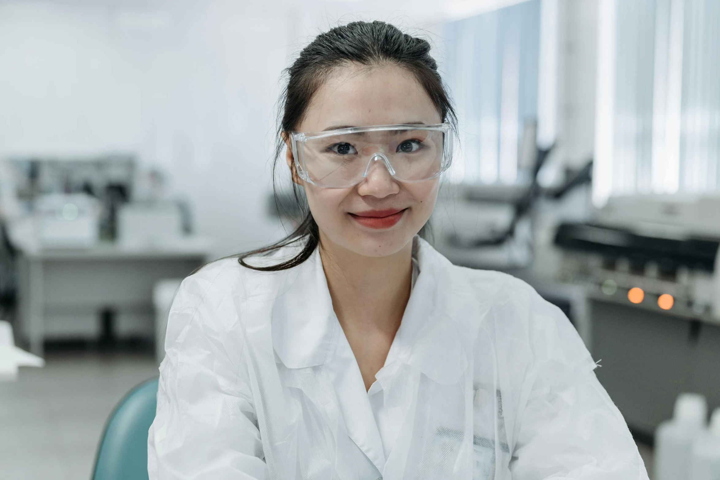 a woman in a lab coat and safety glasses, inspired by Jiang Tingxi, unsplash, gutai group, lachlan bailey, portrait of a female pathologist, low quality photo, white