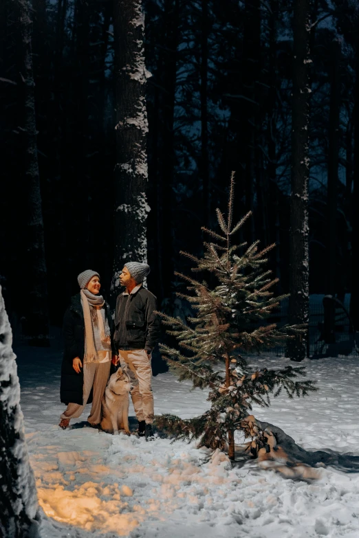 a couple of people that are standing in the snow, a colorized photo, by Jaakko Mattila, pexels contest winner, symbolism, forest at night, islamic, instagram story, cozy environment