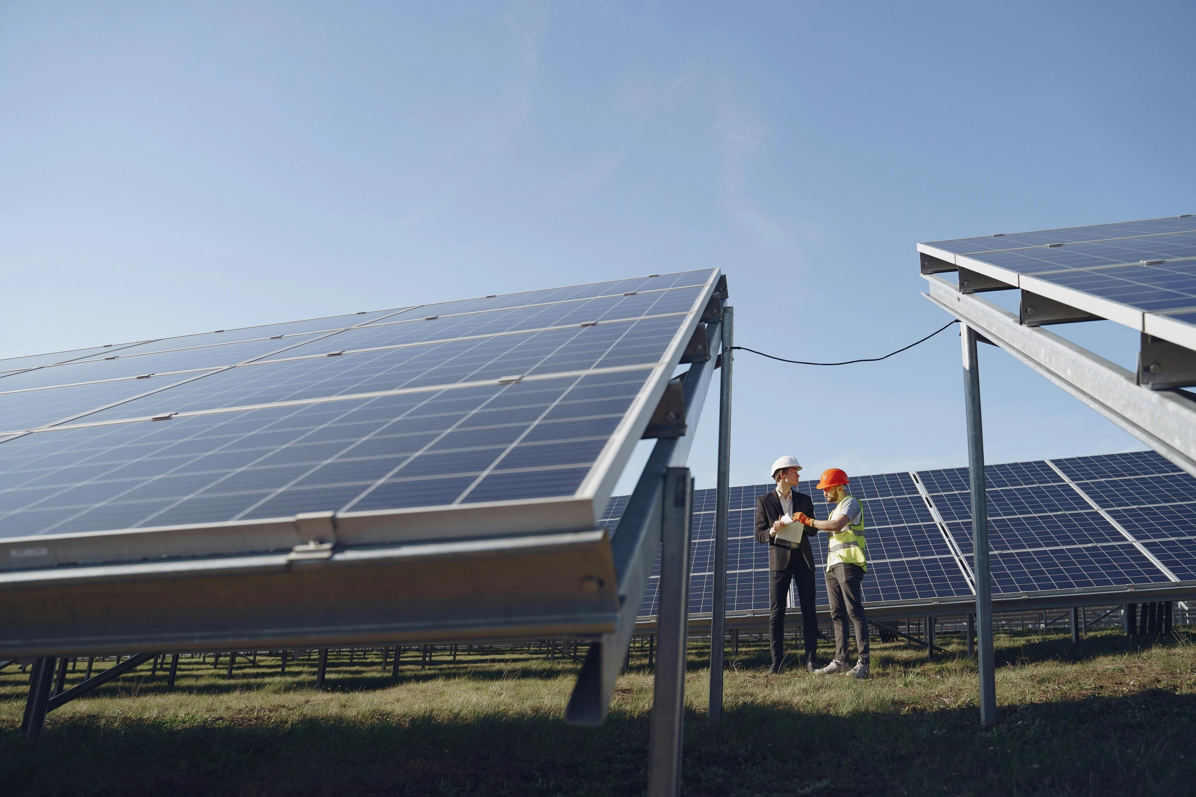 two workers standing in front of solar panels, pexels contest winner, bauhaus, ground - level medium shot, planted charge, low quality photo, thumbnail