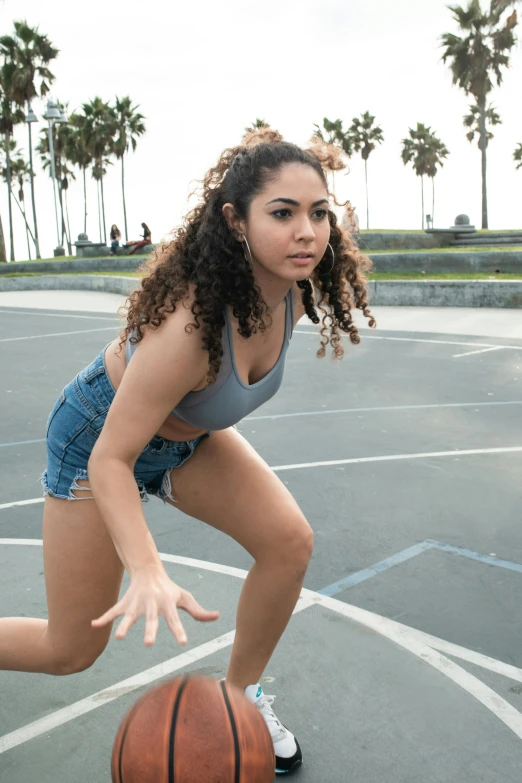 a young woman dribbling a basketball on a court, an album cover, trending on pexels, curls, hispanic, actress, parkour