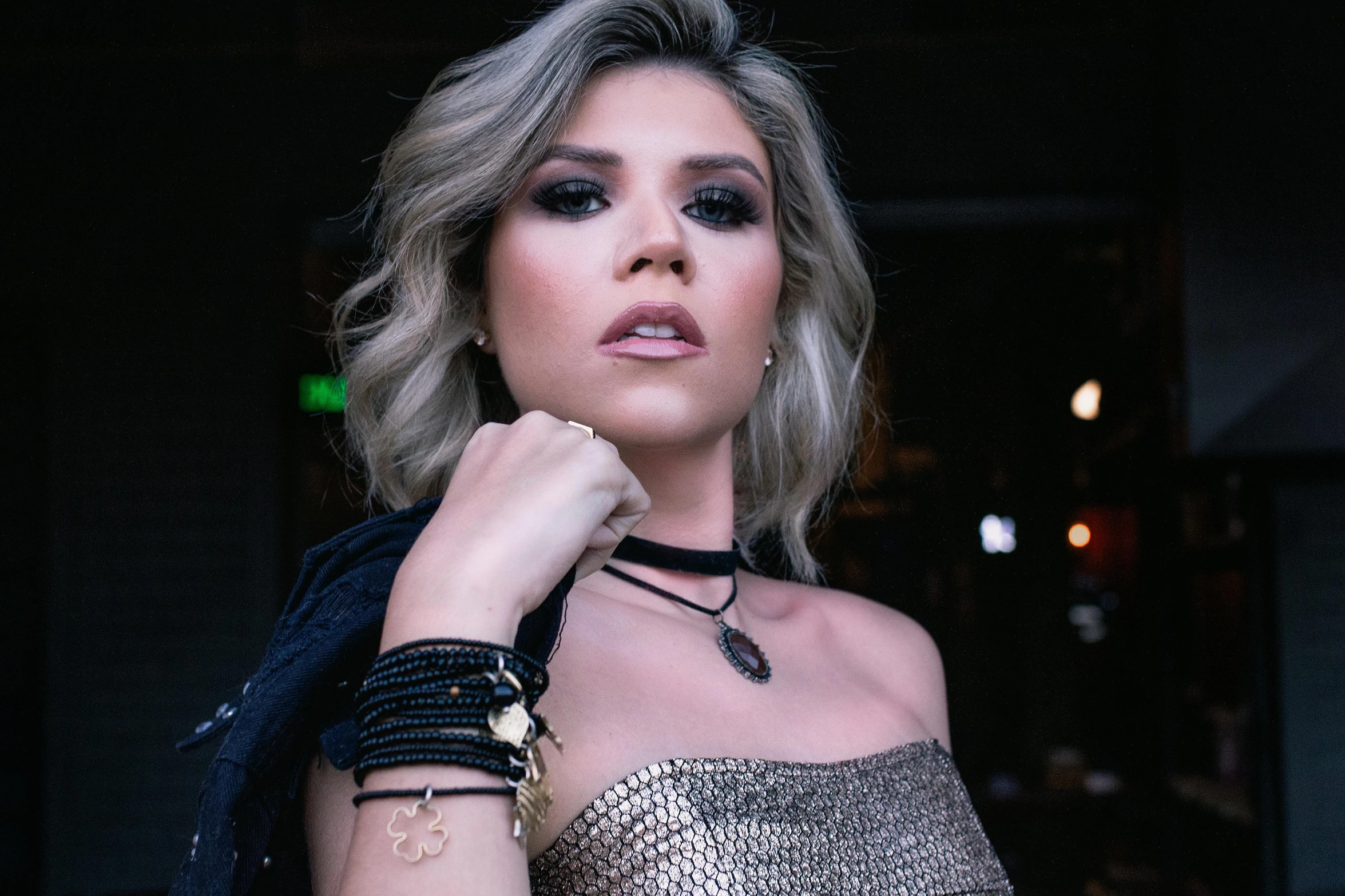 a woman in a gold dress posing for a picture, an album cover, inspired by Elsa Bleda, trending on pexels, graffiti, black leather choker, leather jewelry, with professional makeup, threyda