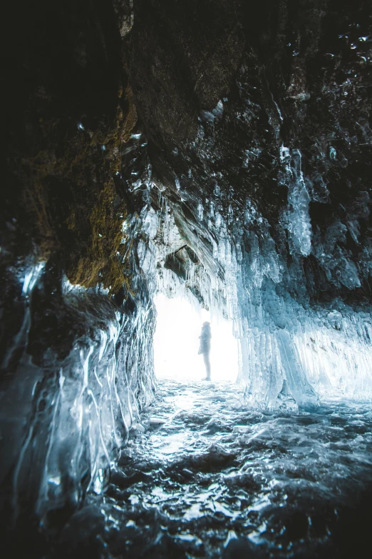 a person standing in the middle of a cave, by Jesper Knudsen, unsplash contest winner, romanticism, icicle, 8 k ), 4k)