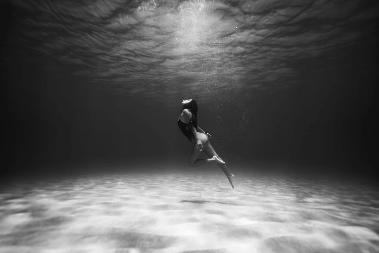 a black and white photo of a woman swimming in the ocean, by John Hutton, abzu, 4k greyscale hd photography, under the ocean, kiss