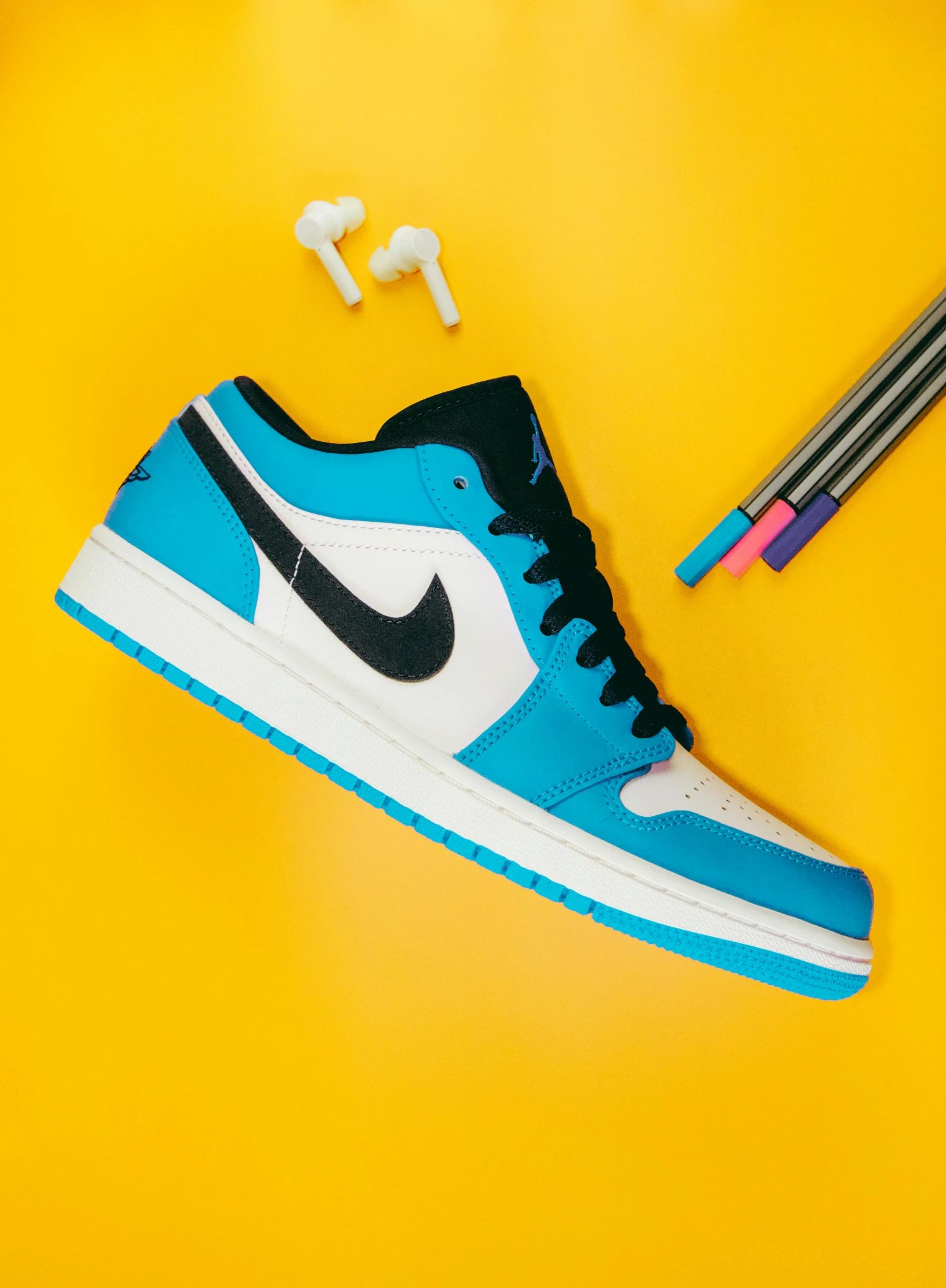 a pair of sneakers sitting on top of a yellow surface, inspired by Zhu Da, black and cyan color scheme, “air jordan 1, low shot, vibrant high contrast coloring