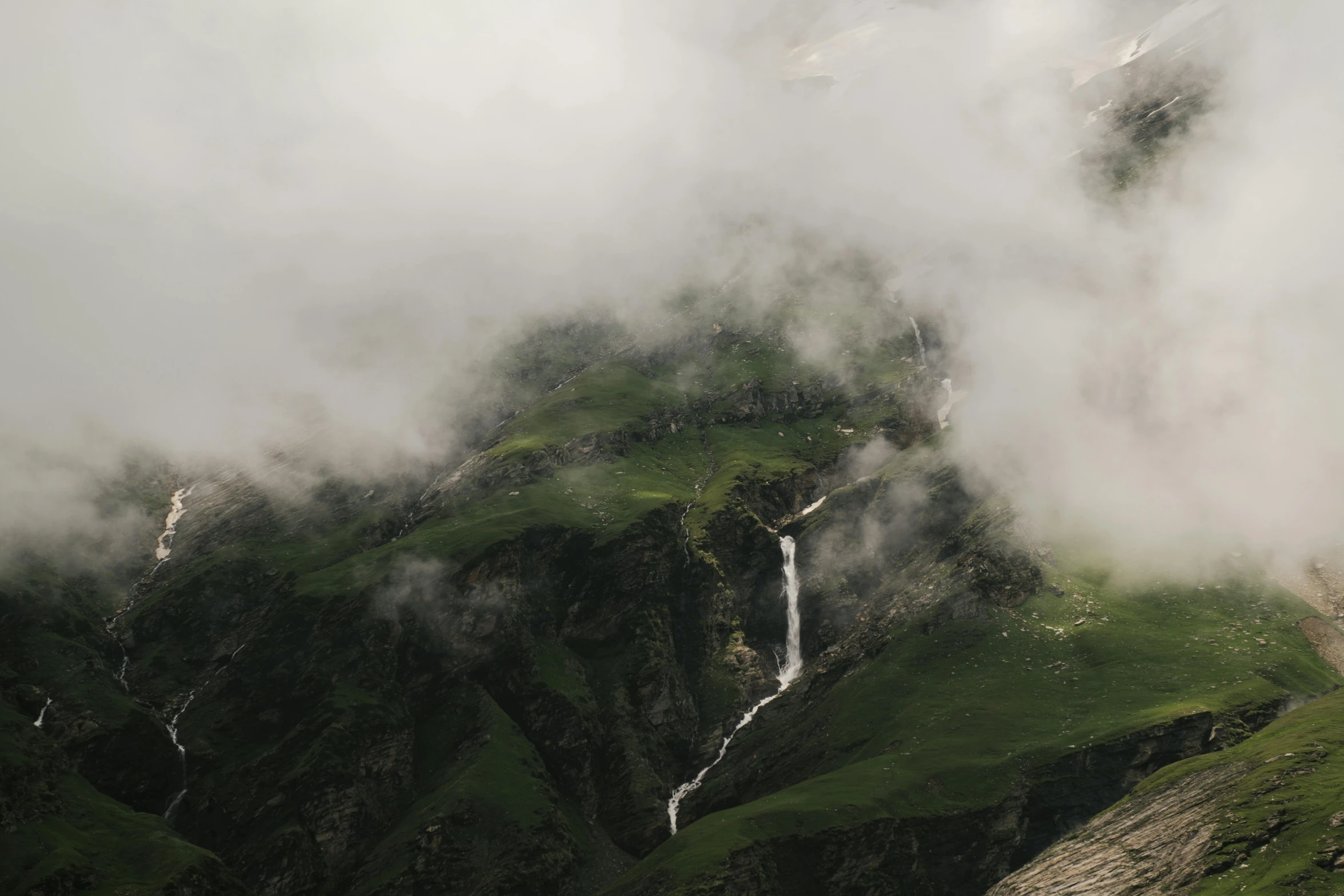 a herd of sheep standing on top of a lush green hillside, pexels contest winner, hurufiyya, waterfall. fog, alessio albi, view from helicopter, melting clouds