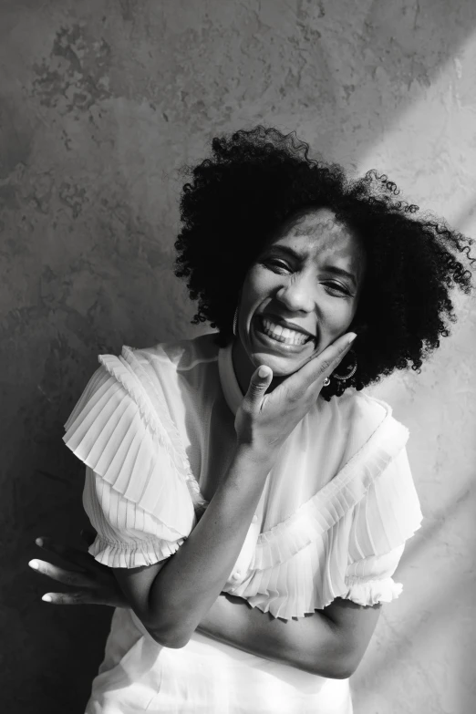 a black and white photo of a woman laughing, a black and white photo, inspired by Carrie Mae Weems, pexels contest winner, black arts movement, willow smith young, clothed in white shirt, unhappy, afro