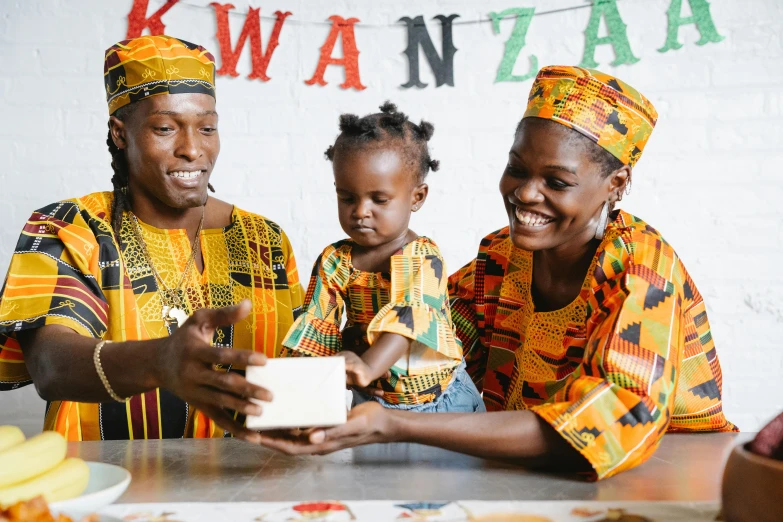 a group of women standing next to each other at a table, by Ingrida Kadaka, pexels contest winner, portrait of family of three, wearing an african dress, giving gifts to people, promotional image