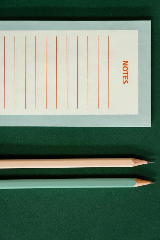 a pencil sitting on top of a piece of paper, green and orange theme, 3 - piece, curated collections, detail shot