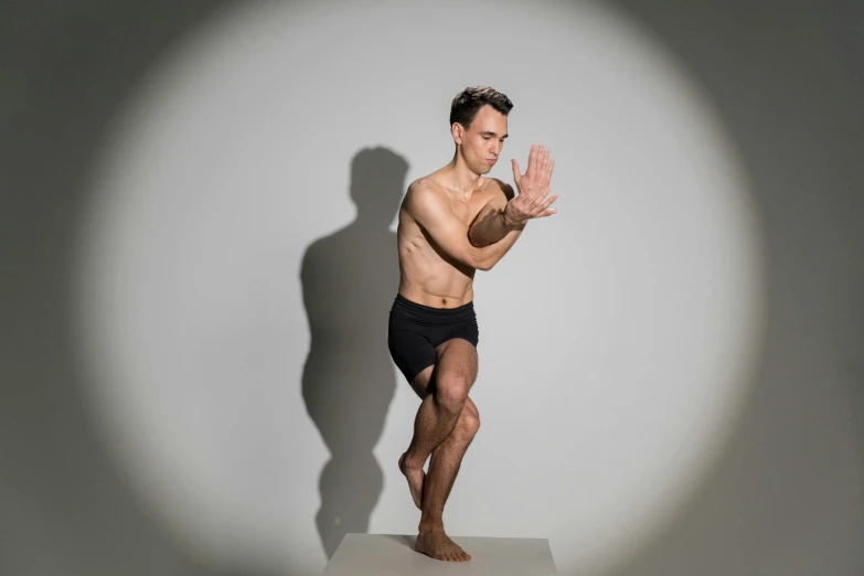 a man standing on top of a white pedestal, by Julian Allen, arabesque, dynamic active running pose, looking across the shoulder, squatting pose, studio photoshoot