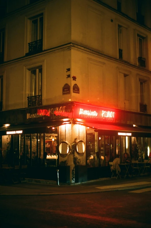 a restaurant on the corner of a street at night, a photo, trending on unsplash, art nouveau, very smoky paris bar, 2 0 0 0's photo, fan favorite, taken with kodak portra