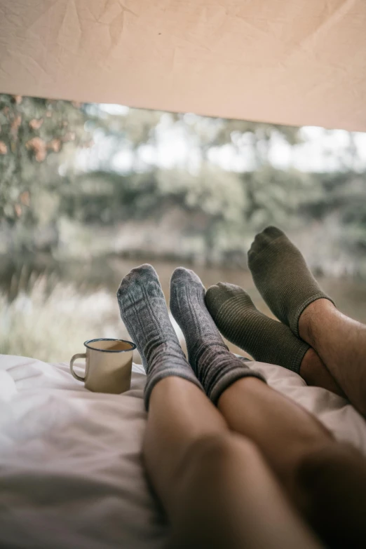 a couple of people sitting on top of a bed, by Jessie Algie, unsplash contest winner, socks, lush nature, lachlan bailey, coffee