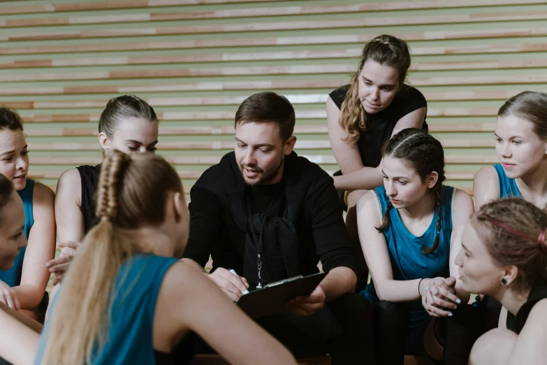 a group of young women sitting on top of a wooden floor, by Nina Hamnett, pexels contest winner, danube school, local gym, lachlan bailey, looking across the shoulder, holding court