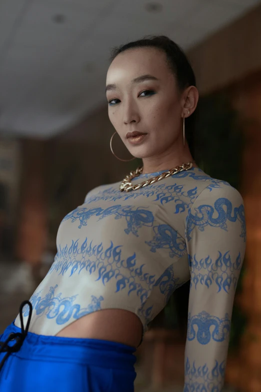 a woman in a blue skirt posing for a picture, an album cover, inspired by Zhu Da, trending on cg society, patterned clothing, intricate latex set, detail shot, wearing tight shirt