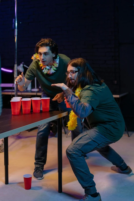 a group of people playing a game of ping pong, by Ryan Pancoast, [ theatrical ], holding a drink, markiplier, flowers around