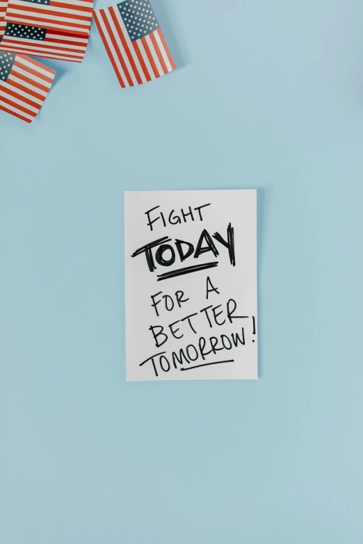 a note that says fight today for a better tomorrow, by Julia Pishtar, focus on card, white, 1, healthcare