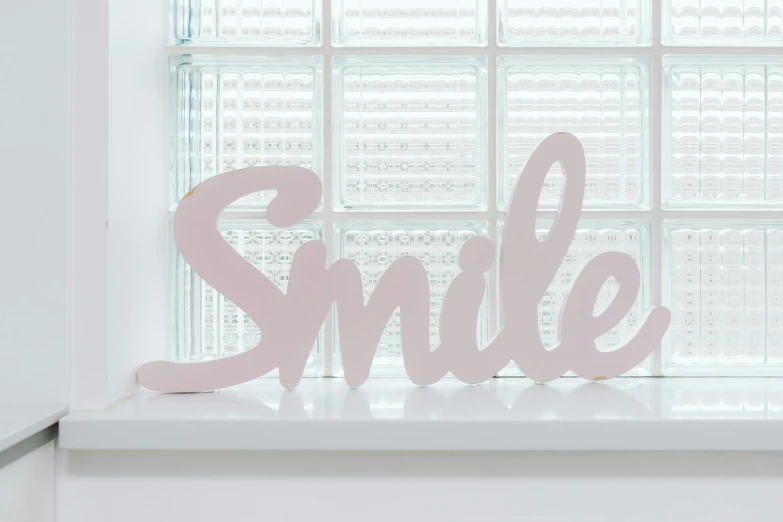 a close up of a sign on a window sill, featured on pinterest, smug smile, light pink, official product photo, large